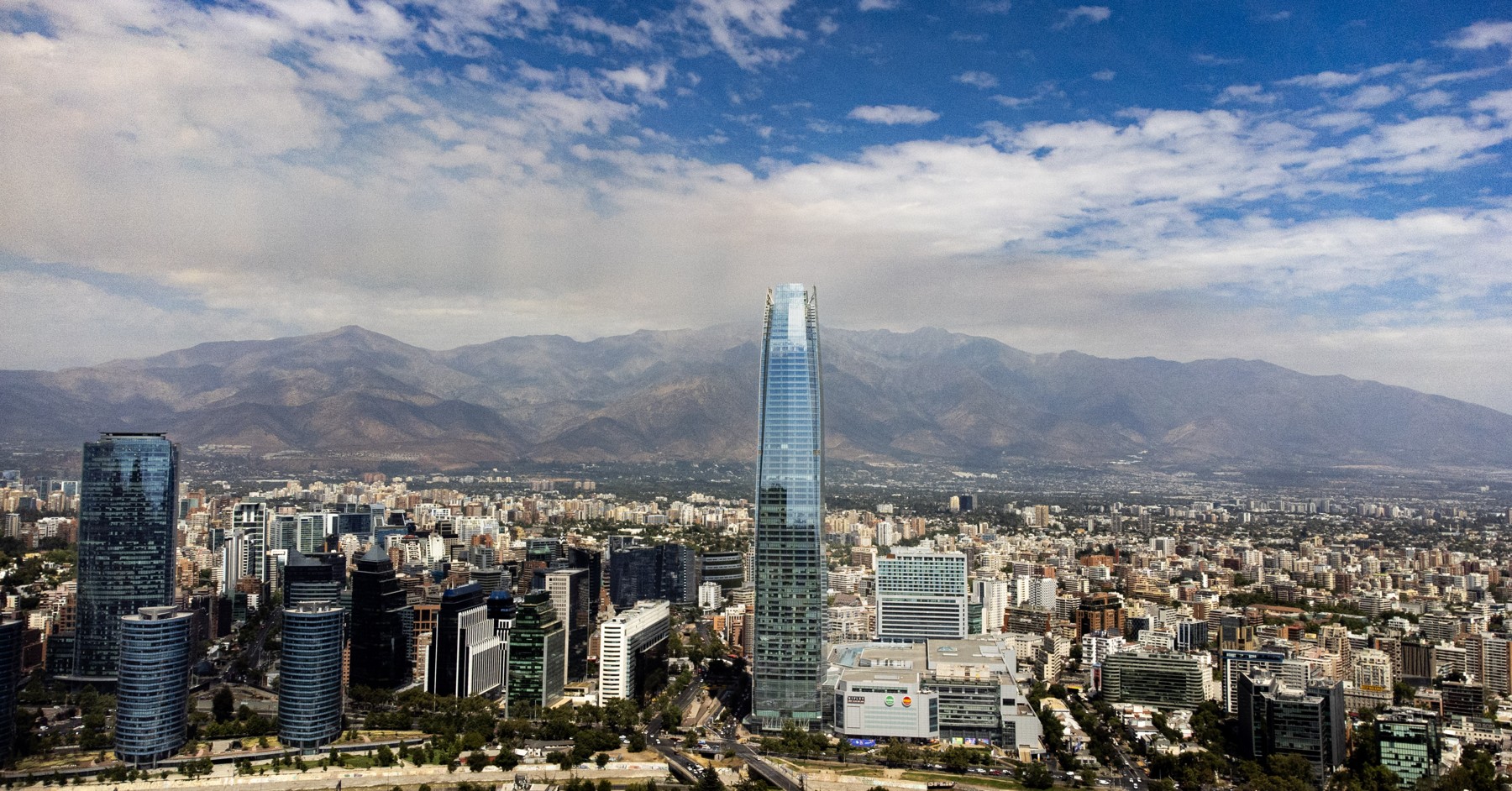 Fotografía de Santiago con la Gran Torre Costanera y la cordillera de los Andes al fondo.
